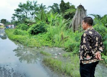 Bupati Simalungun Buat Aliran Air saat Melintasi Jalan yang Digenangi Air