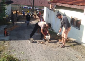 Untuk Kelancaran Berkendara, Bhabinkamtibmas Aek Muara Bersama Warga Gotong Royong Tambal Jalan Berlubang