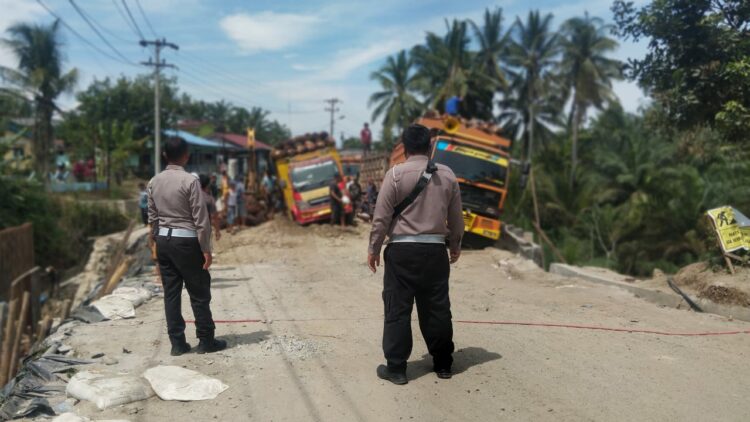 Polsek Tanah Jawa Lakukan Pengamanan dan Pengaturan Lalulintas di Lokasi Perbaikan Jalan Hatonduhan