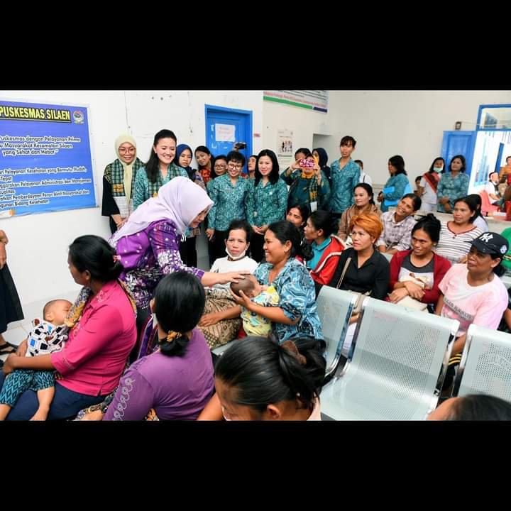 Ketua TP PKK Sumut Nawal Lubis mengelus sayang kepala seorang anak balita di Kabupaten Toba