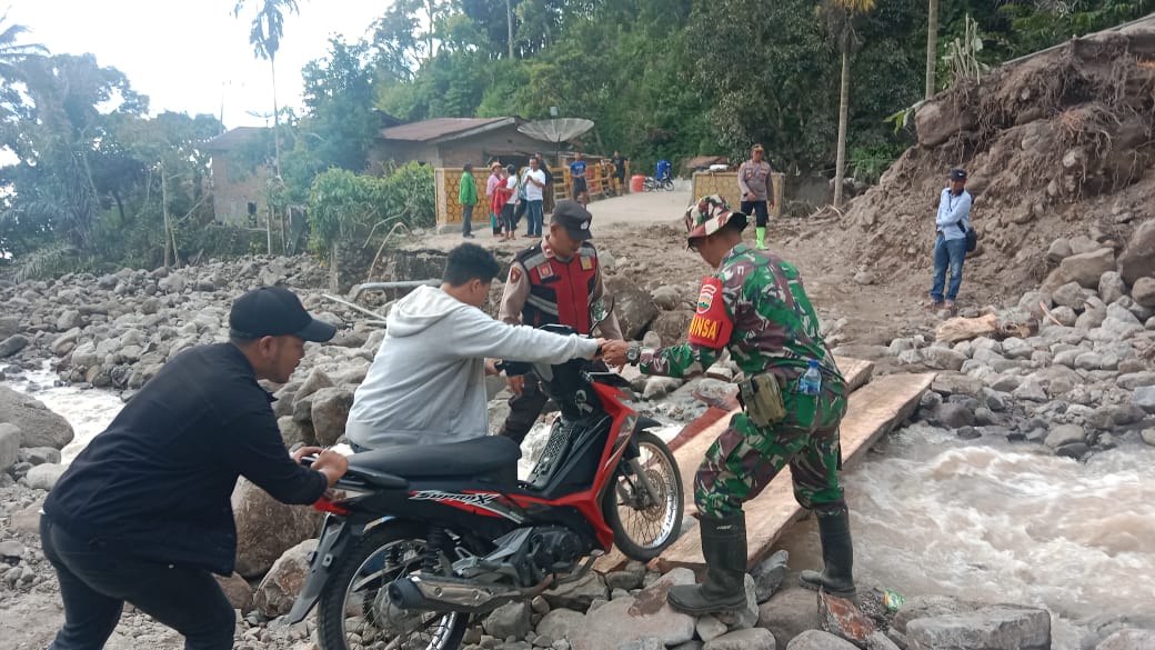 Jalan putus masih dipasangi lembaran papan sehingga belum dapat dilalui dengan lancar dan dijaga APH