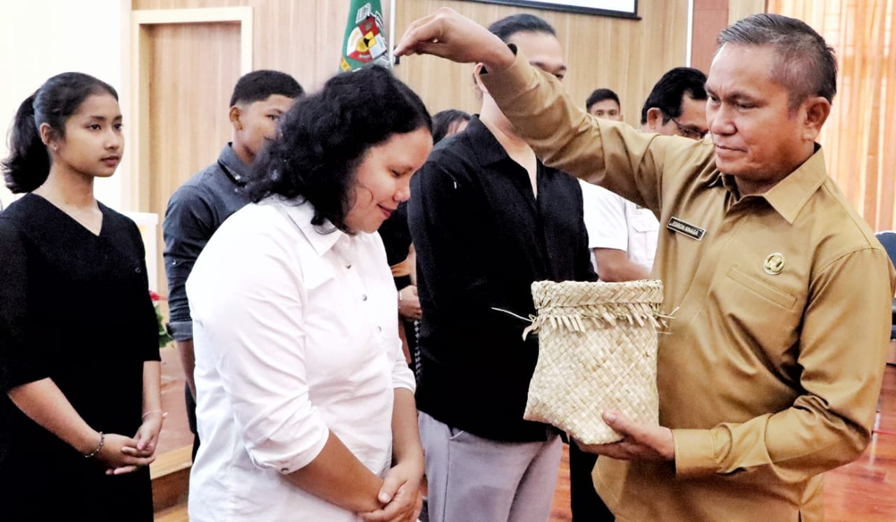 Sekda Esron Sinaga memberi Boras Tenger kepada peserta Pesparawi Kab. Simalungun