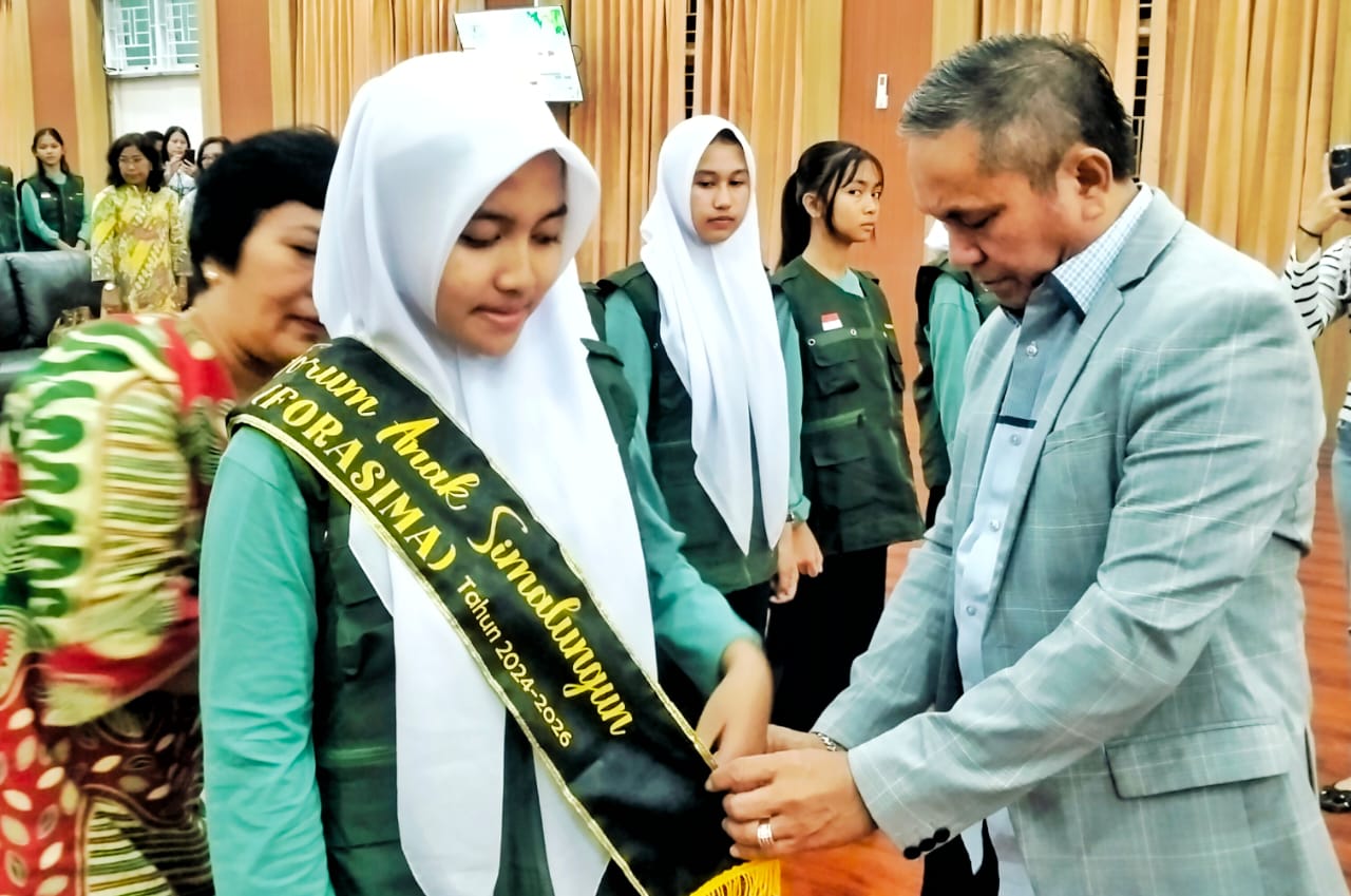 Sekdakab Simalungun Esron Sinaga saat menyematkan selempang kepengurusan FORASIMA periode 2024 - 2026