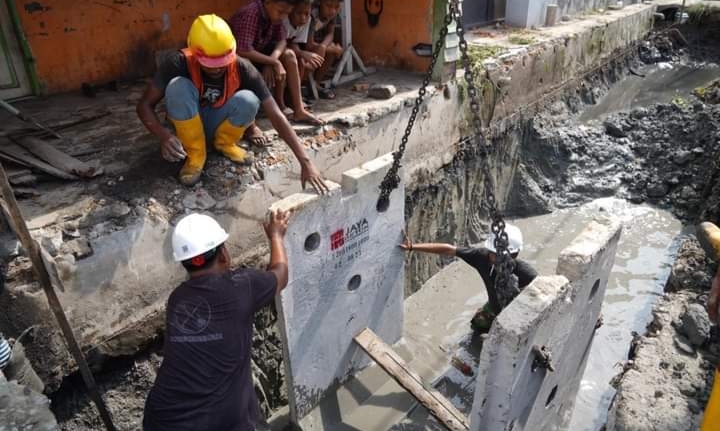 Petugas memasang u-ditch di dalam saluran drainase (ist)