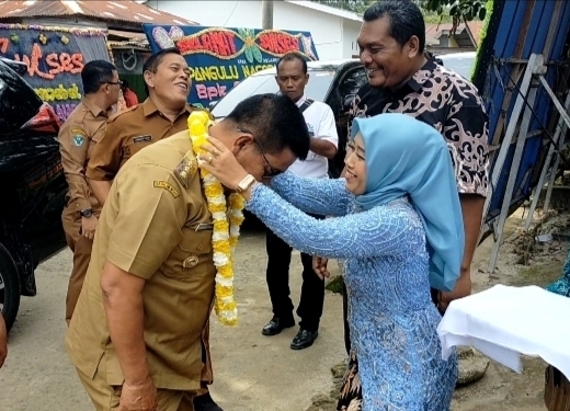 Ketua PKK Nagori Moho, Kecamatan Jawa Maraja Bah Jambi, Supiani saat mengalungkan untaian bunga kepada Bupati Simalungun, Radiapoh Hasiholan Sinaga