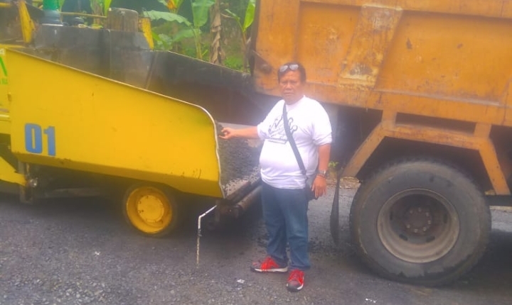 Wartawan pegang AMP yang baru dicurah dari DT ke alat berat penyebar atau Aspahlt Finisher