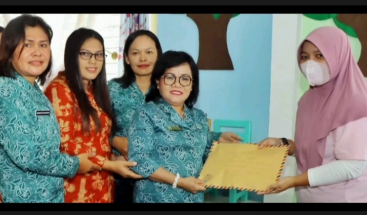 Ketua TP PKK sekaligus pembina DPW Simalungun menyerahkan tali asih kepada ketua RRABK, Erlina Sinaga
