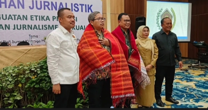 Ketua DK PWI Pusat Sasongko Tedjo dan Ketua Komisi Pendidikan, Pelatihan dan Pengembangan Profesi Dewan Pers, Paulus Tri Agung Kristanto disematkan ulos.(ist)