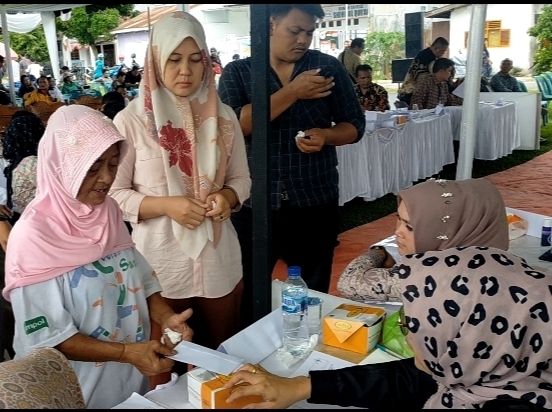 Salah seorang warga DPT TPS 1 Rambung Merah menerima uang di isi dalam amplop dan sekotak kue (snack)