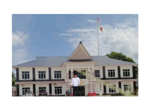 Camat Kecamatan Bandar, Tagon Sihotang membelakangi kantor Camat yang dibangun megah
