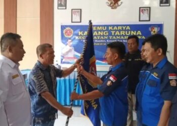 Camat Tanah Jawa Maryaman Samosir selaku pembina Karang Taruna Kecamatan Tanah Jawa menyerahkan Pataka Karang Taruna kepada ketua terpilih Sanggam Manik