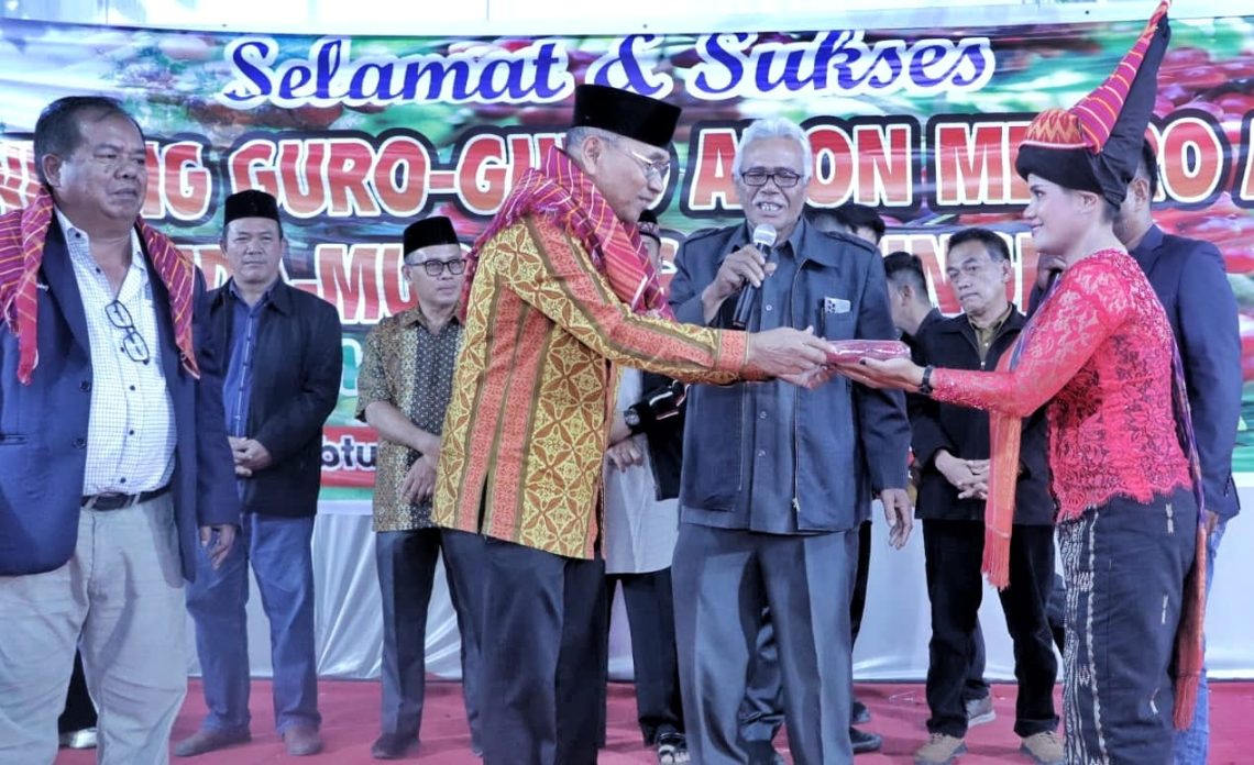 Warga Nagori Cingkes menyerahkan seperangkat pakaian adat Karo kepada Bupati Anton Achmad Saragih dipandu oleh Pangulu Nagori Cingkes Hamid Tarigan