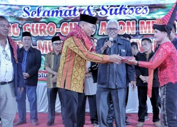 Warga Nagori Cingkes menyerahkan seperangkat pakaian adat Karo kepada Bupati Anton Achmad Saragih dipandu oleh Pangulu Nagori Cingkes Hamid Tarigan