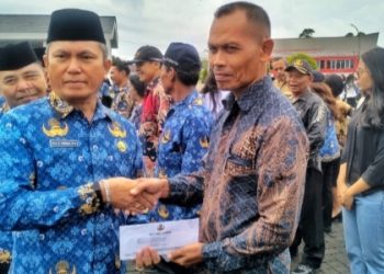 Sekdakab Simalungun, Esron Sinaga saat menyerahkan tali asih kepada salah seorang anggota KORPRI