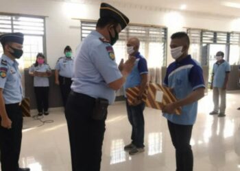 Kepala Lapas Klas II B Kota Tebingtinggi Theo Andreanus Purba menyerahkan remisi kepada salah satu warga binaan.