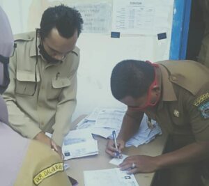 Lurah Melayu, Sugianto setelah memeriksa kelengkapan data penerima BLT, menandatangani nomor antrian.