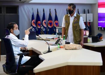 Presiden Joko Widodo meninjau kantor Gugus Tugas Percepatan Penanganan Covid-19 di Graha Badan Nasional Penanggulangan Bencana (BNPB), Jakarta Timur pada Rabu, 10 Juni 2020. Presiden Jokowi menyampaikan lima arahan terkait adaptasi kebiasaan baru agar masyarakat tetap produktif dan aman dari penularan Covid-19. Pemerintah pusat, daerah, serta elemen masyarakat harus bergotong royong dan bersinergi dalam menyelesaikan persoalan pandemi Covid-19.