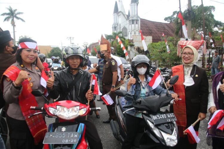 Kaban Kesbangpol Sofie Saragih SSTP Bersama Kapolres Pematang Siantar AKBP Fernando SH SIK dan Unsur Forkopimda membagikan bendera Merah Putih (f:ist)