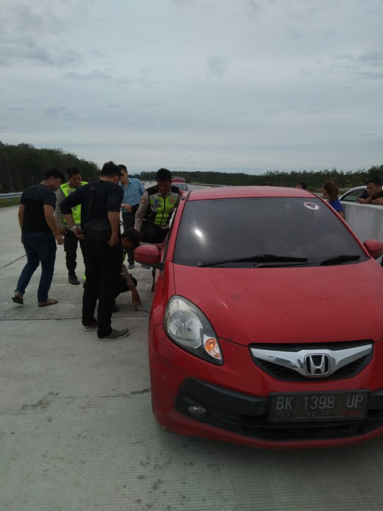 Bantuan/pertolongan kepada pengendara mobil yang mengalami pecah ban (f:ist/konstruktif)