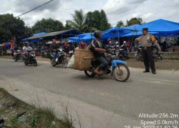 Personel Bhabinkamtibmas patroli di Pekan  tradisonal di Huta Karang Sari (f:ist/konstruktif)