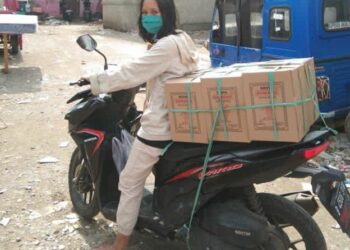 Yuni Sri Rahayu mengantarkan makanan kripik bawang ke pelanggan.