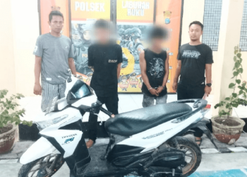 Kedua tersangka (tengah) berikut sepeda motor yang mereka curi saat berada di Polsek Labuhan Ruku.(f:ist/konstruktif)