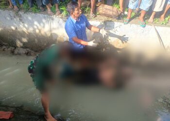 Mayat Lawaden Purba (64) yang ditemukan tertelungkup di saluran irigasi Panei Tongah saat hendak dievakuasi personel Polres Simalungun.( Nawasenanews/ Ist)