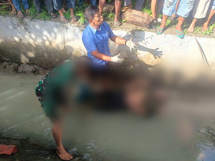 Mayat Lawaden Purba (64) yang ditemukan tertelungkup di saluran irigasi Panei Tongah saat hendak dievakuasi personel Polres Simalungun.( Nawasenanews/ Ist)
