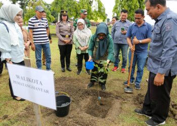 Wali Kota menyiram bibit pohon yang baru saja ditanamnya dalam rangka memperingati Hari Air Dunia ke- 32 dan Forum Air Dunia ke- 10 di areal waduk mata air PDAM Tirta Uli di Simarimbun.( Nawasenanews/ Ist)