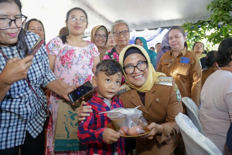 Wali Kota Pematangsiantar foto bersama seorang anak yang diberi makanan tambahan pada acara pencanangan intervensi stunting di Kelurahan Sigulang- gulang,Siantar Utara.(Nawasenanews/ Ist)