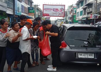 Komunitas Tamado Grup berbagi makanan pada momen Jumat berbagi kepada para tukang parkir, ojek online dan pedagang kaki lima di seputaran jalan Sutomo dan Merdeka Pematangsiantar, Jumat (28/06/2024).(Nawasenanews/ Ist)