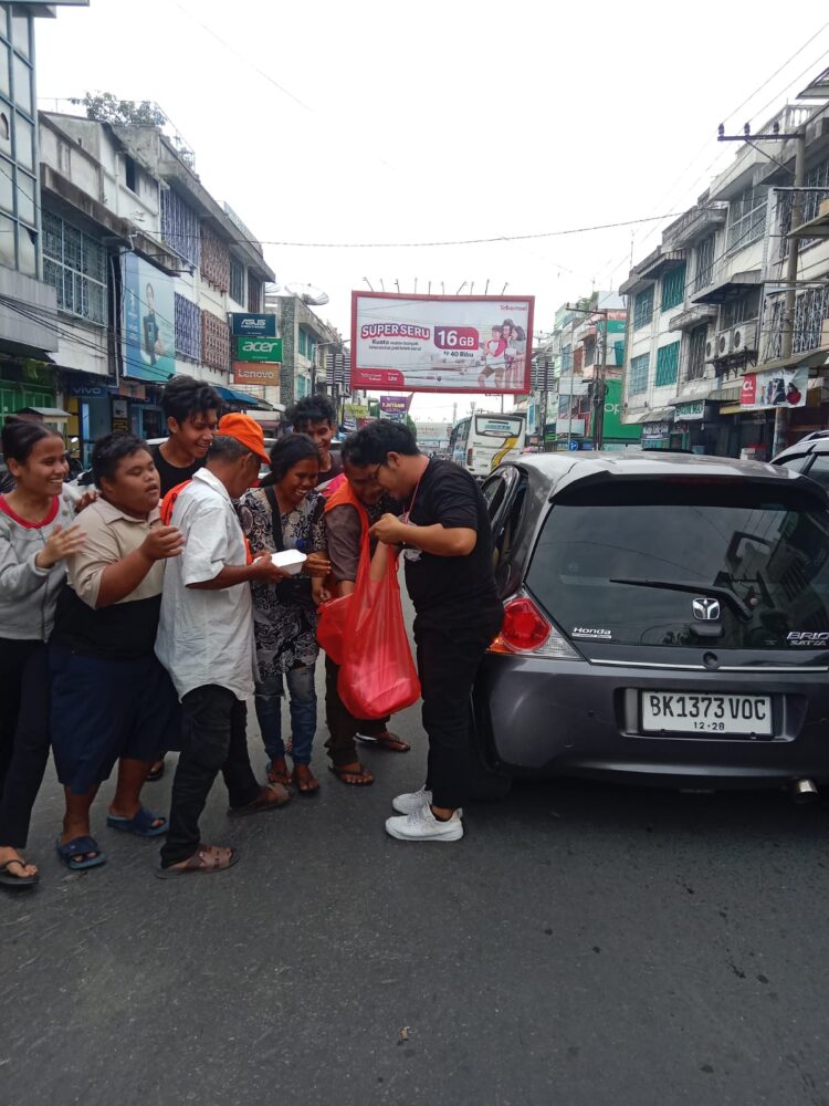 Komunitas Tamado Grup berbagi makanan pada momen Jumat berbagi kepada para tukang parkir, ojek online dan pedagang kaki lima di seputaran jalan Sutomo dan Merdeka Pematangsiantar, Jumat (28/06/2024).(Nawasenanews/ Ist)