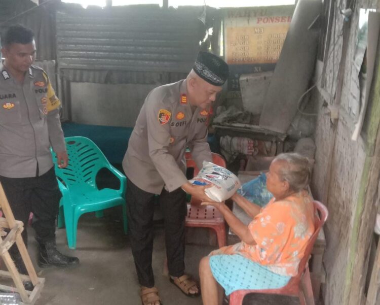 Kapolsek Perdagangan saat menyalurkan bantuan kepada warga dalam rangka Jumat berkah. ( Nawasenanews/ Ist)