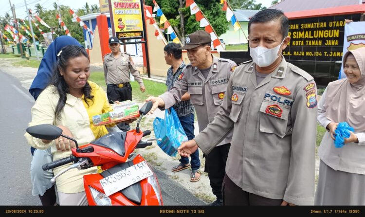 Polsek Tanah Jawa menggelar kegiatan sosial bertajuk Jumat Berkah dengan membagikan nasi kotak kepada masyarakat sekitar dan para pengendara motor yang melintas di depan Markas Komando (Mako) Polsek Tanah Jawa.( Nawasenanews/ Ist)