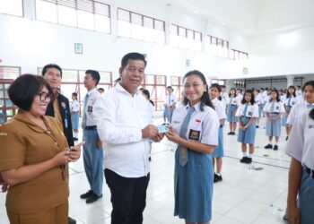 Bupati Simalungun Radiapoh Hasiholan Sinaga menyerahkan E- KTP bagi salah seorang siswi SMA yang merupakan pemilih pemula di Raya. ( Nawasenanews/ Ist)