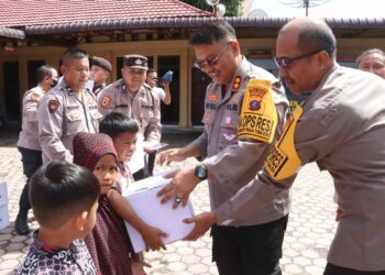 Kapolres Simalungun AKBP Choky Sentosa Meliala menyerahkan bingkisan kepada anak - anak yatim piatu dalam acara doa bersama dan bakti sosial sebagai ucapan syukur terlaksananya Pilkada 2004 yang aman dan lancar.( Nawasenanews/ Ist)