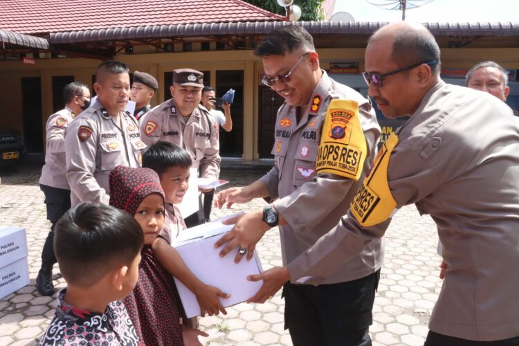 Kapolres Simalungun AKBP Choky Sentosa Meliala menyerahkan bingkisan kepada anak - anak yatim piatu dalam acara doa bersama dan bakti sosial sebagai ucapan syukur terlaksananya Pilkada 2004 yang aman dan lancar.( Nawasenanews/ Ist)