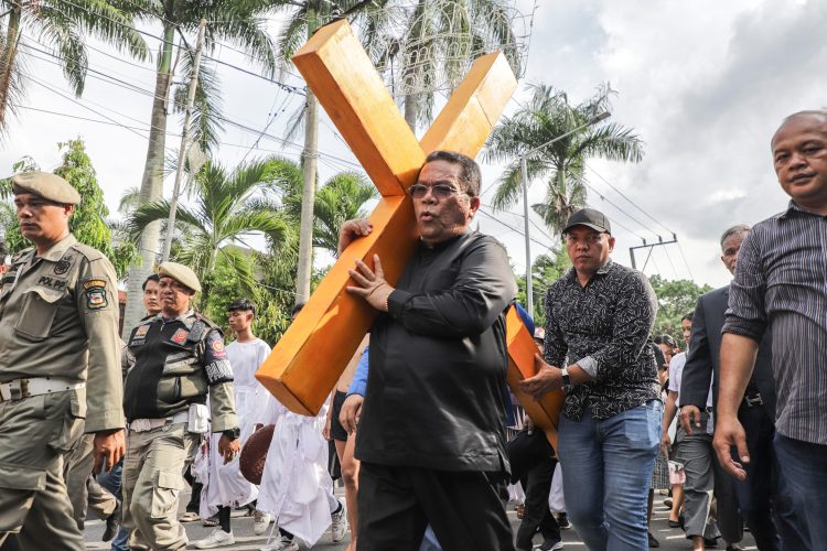Wali Kota Wesly Silalahi SH MKn mengikuti prosesi Jalan Salib dan turut memikul kayu salib di acara peringatan Jumat Agung.( Ist/ Mar/ Nawasenanews)