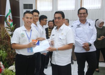 Asisten Perekonomian dan Pembangunan menyerahkan sertifikat, Kartu AK-1, dan buku tabungan secara simbolis kepada peserta pelatihan.( Ist/ Nawasenanews)