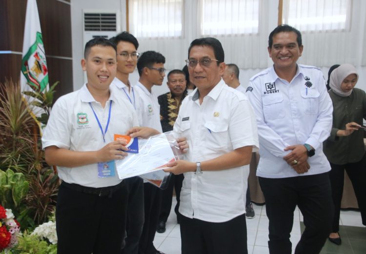 Asisten Perekonomian dan Pembangunan menyerahkan sertifikat, Kartu AK-1, dan buku tabungan secara simbolis kepada peserta pelatihan.( Ist/ Nawasenanews)