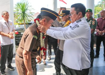 Wali Kota Pematangsiantar Wesly Silalahi mengalungkan bunga kepada Erwin Purba sebagai tanda ucapan selamat datang ( Ist/ Nawasenanews)