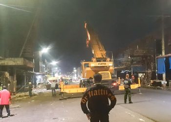 Proses pembongkaran jembatan penyeberangan yang menghubungkan Gedung III dan Gedung IV Pasar Horas menggunakan crane dari PT STTC, dengan melakukan pemotongan dan pengangkatan secara bertahap oleh Dinas PUTR Kota Pematangsiantar, Minggu malam (05/10/2025).( Nawasenanews/ Ist)