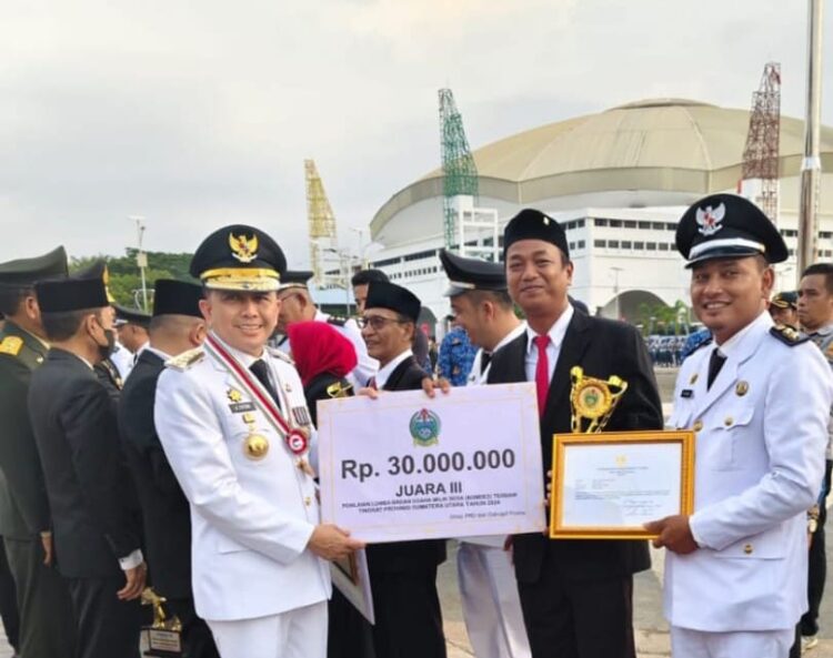 Pj Gubernur Sumut Agus Fatoni serahkan Trofi dan hadiah juara ke lll kepada Pangulu Bosar Bayu Edu Sitorus bersama pengurus BUMNag Tama Ture pada perlombaan BUMNag terbaik Tingkat Provinsi Sumut (17/08/2024)
