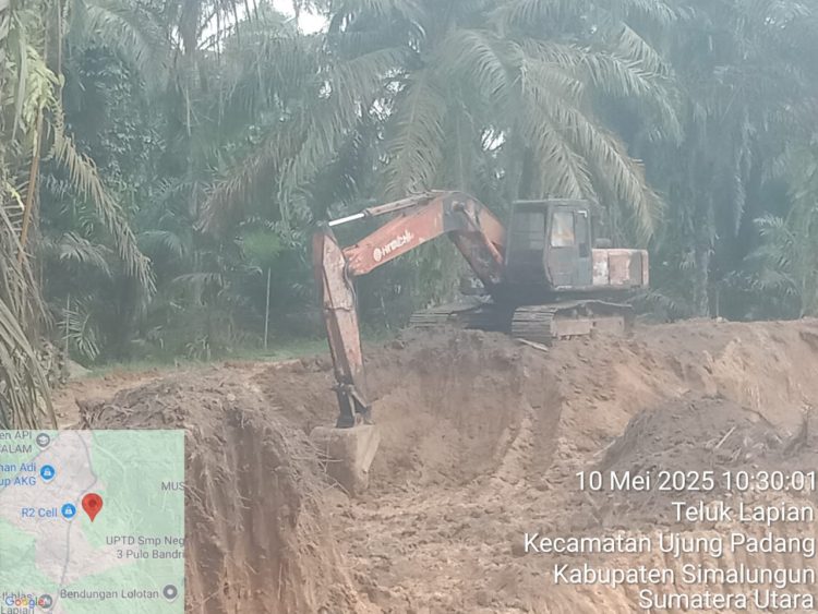 Terpantau aktivitas salah satu alat berat excavator sedang mengeruk tanah urug yang akan dimuat ke dalam Dump Truk di Nagori Teluk Lapian, Kecamatan Ujung Padang, Simalungun.