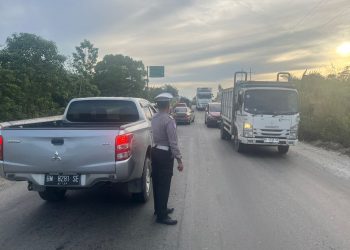 Polsek Tualang Lakukan Pengaturan Sistem Buka-Tutup Arus Lalu-lintas di Simpang Bakal Demi Kelancaran Perbaikan Jalan
