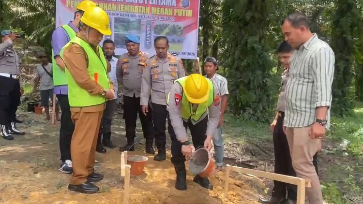 Kapolres Labuhanbatu Selatan, AKBP Aditya S.P. Sembiring, S.I.K.,saat melakukan peletakan batu pertama pada pembangunan jembatan merah putih presisi.