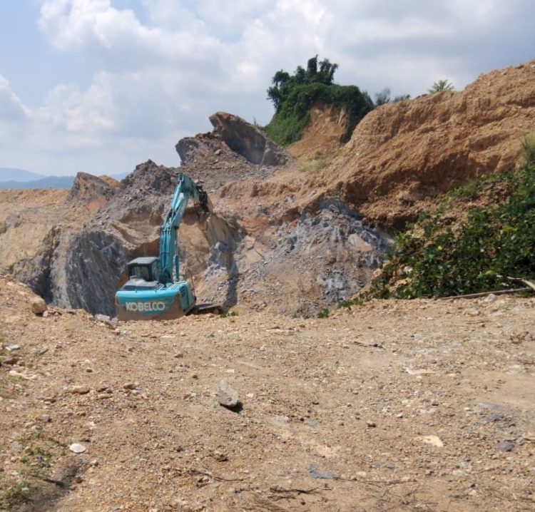 Terlihat sebuah alat berat sedang melakukan penggalian batu dan tanah urug ditengah perkebunan PT.SPR