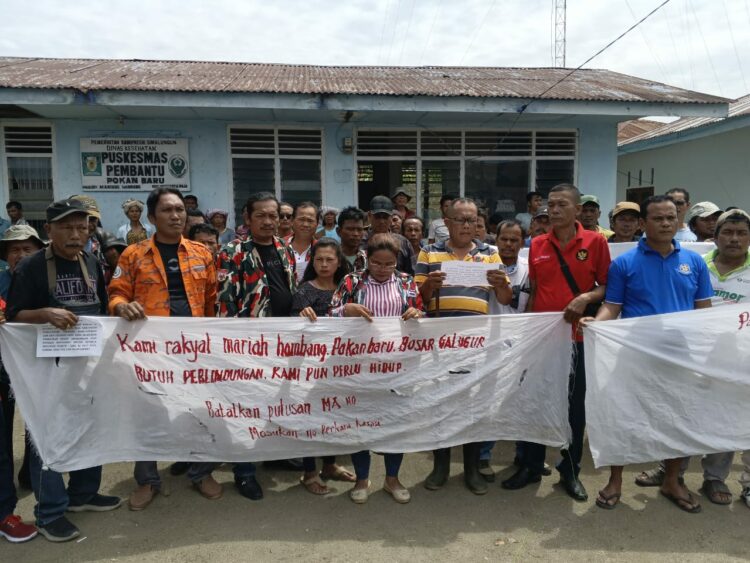 Ketua Petani Dosroha, Helarius Gultom saat membacakan pernyataan sikap didampingi ratusan warga dari tiga Desa di Huta Bayu Raja.