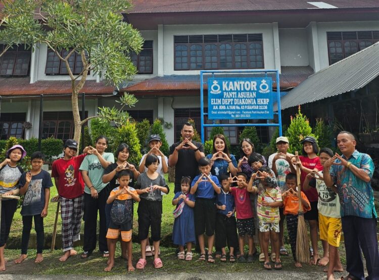 Bonauli Rajagukguk bersama keluarga berfoto dengan pengurus dan anak-anak panti asuhan