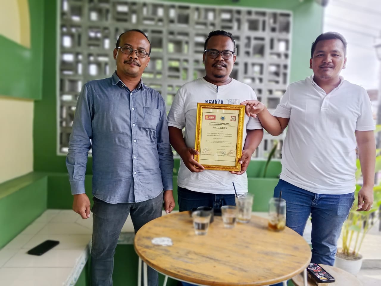 Keterangan Foto: Dari kiri ke kanan; Direktur Senada Institute Candra Malau, Ketua DPK Jaman Kabupaten Simalungun Johannes Sakti Sembiring, dan Ketua Gemapsi Anthony Damanik memperlihatkan Kartu Kuning yang diberikan kepada Bupati dan Wakil Bupati Simalungun, Selasa (04/11/2025)